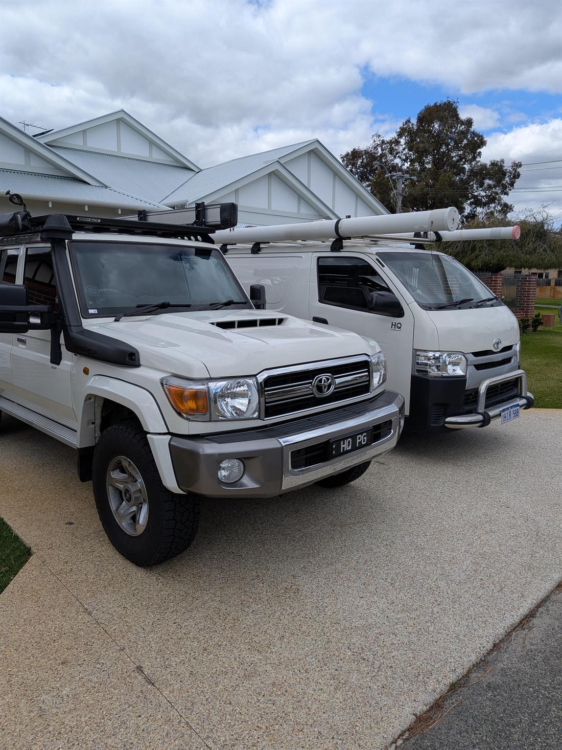 The HQ Plumbing & Gas LandCruiser and van, loaded with pipe, outside a Perth home